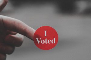 close up of someone holding a sticker that says 'I voted'