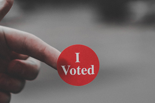 close up of someone holding a sticker that says 'I voted'