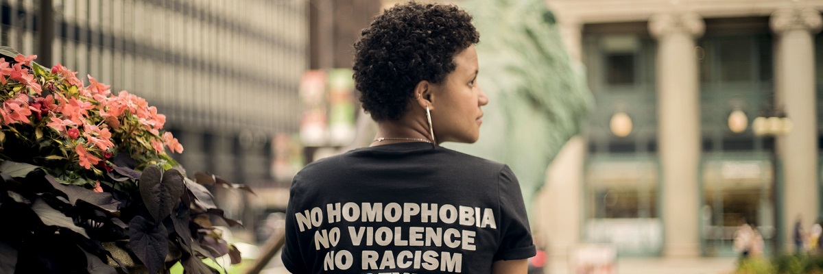 a women wearing a t-shirt that says 'no homophobia, no racism, no violence'