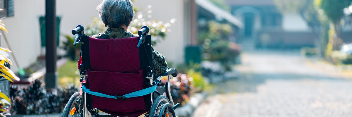 an elderly person sitting in a wheelchair looking into the distance
