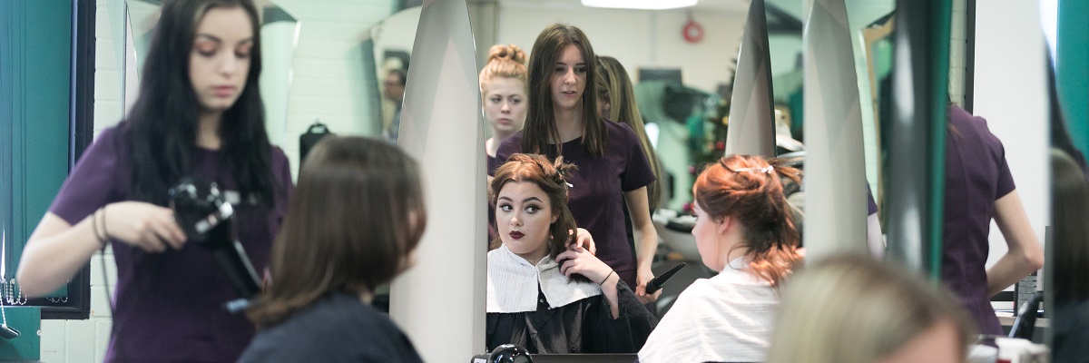 students in the college salon working on client's hair