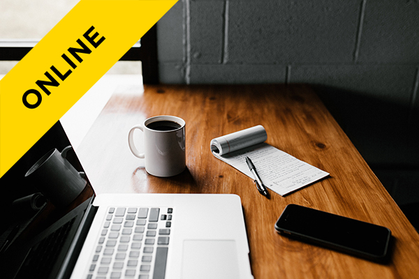 a laptop, cup of coffee and pen/paper on a desk