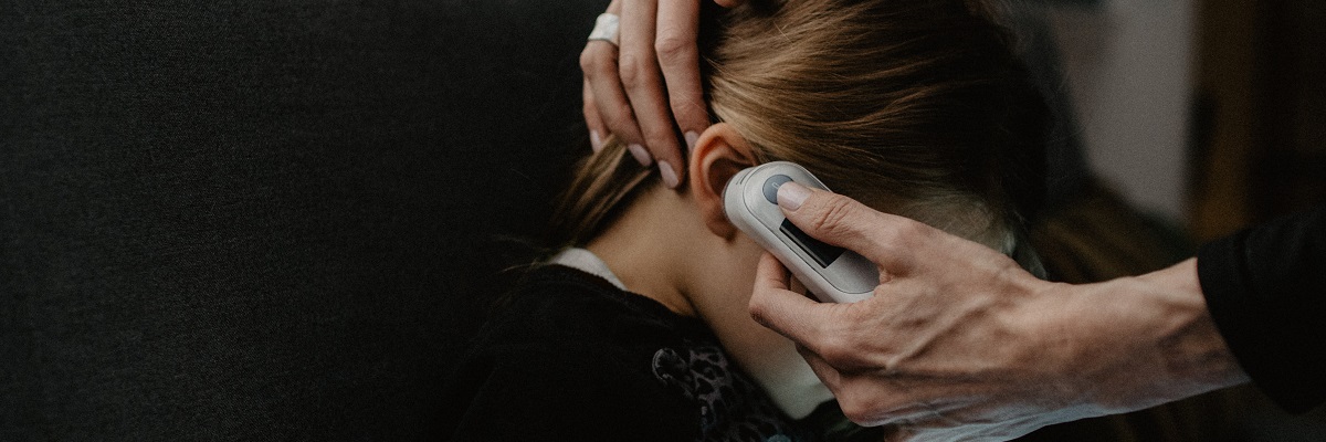 child having their ear temperature checked