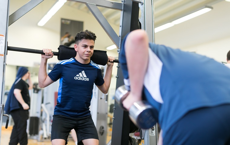 male student using gym equipment