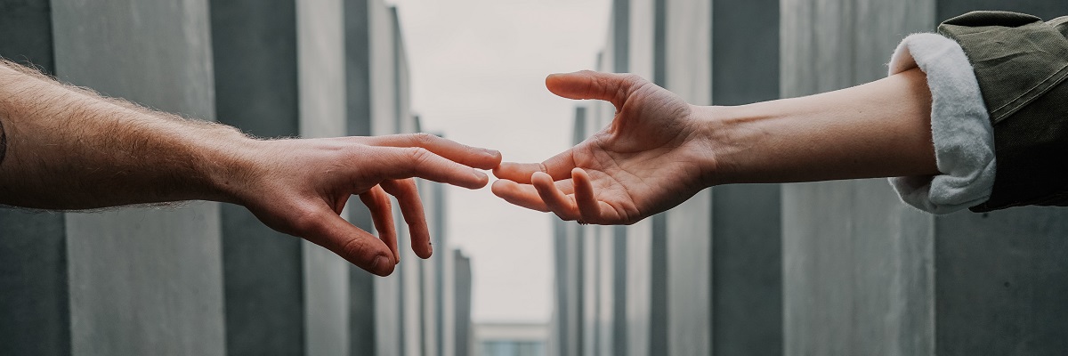 close up of two people reaching out to touch each others hands