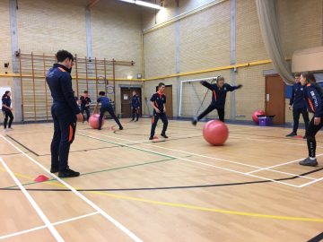Students in the Sports Hall working with exercise balls