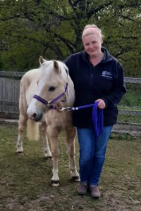 lady standing next to a pony