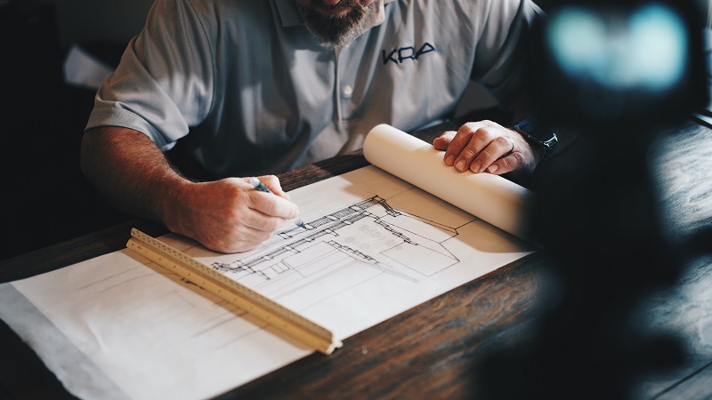 a man drawing up construction plans