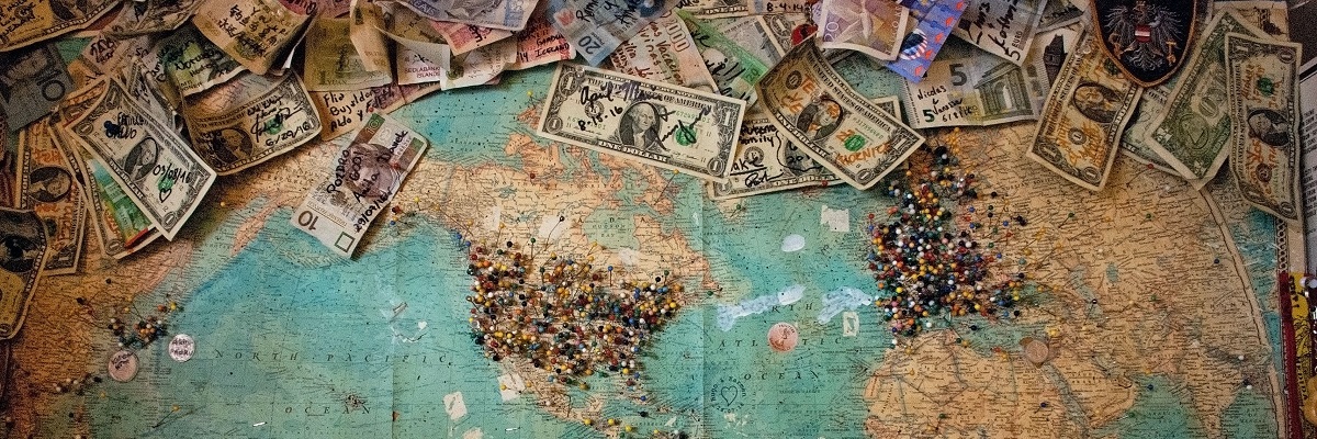 a map ofthe world with pins and currency of the world
