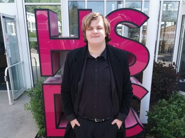 Student smiling in front of HSDC sign