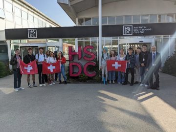 Staff and students hold Swiss flags at HSDC