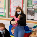 students holding baby simulators