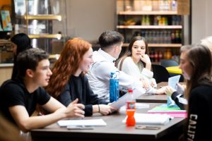 students sat down at a table in the havant canteen area, talking