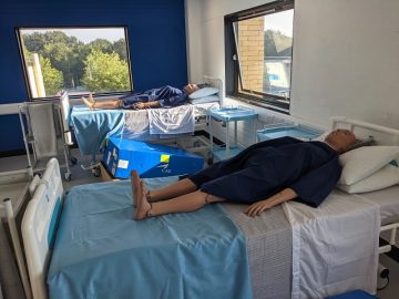 Patient simulators laying on hospital beds