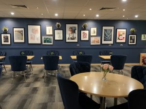 View of restaurant with blue velvet chairs and a photo wall