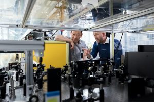 two males looking at machinary