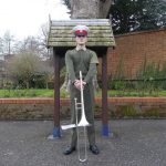 James in his uniform holding his trombone