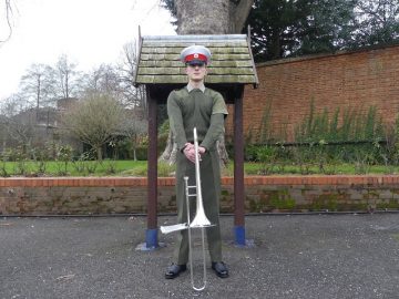 James in his uniform holding his trombone