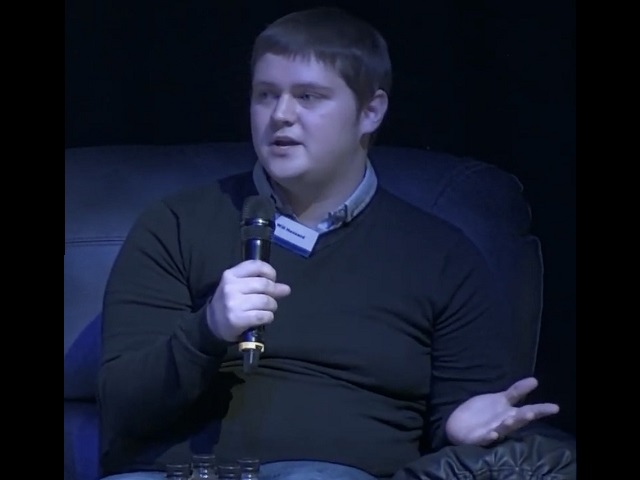 Will on stage at Shaping Portsmouth conference holding a microphone