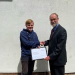 Kieran shaking hands with Steve while receiving his award