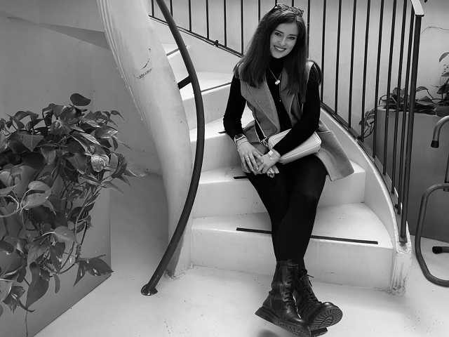 Black and white photo of Grace Abbott sitting on a staircase