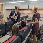 Cabin crew students serving drinks in the aircraft cabin