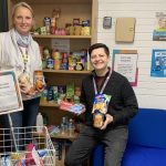 Staff with various dried goods from the food bank