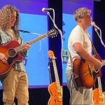 Two students performing on stage holding guitars