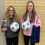 Students holding footballs and kit donations