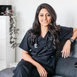 Alisha in scrubs smiling at the camera