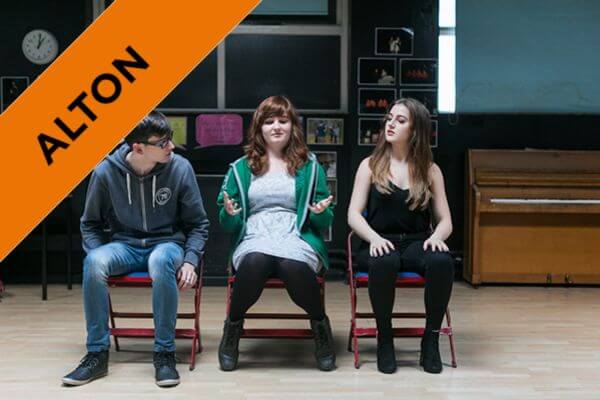 three students in drama class