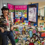 A representative from Open Access Arts poses next to her stall at the creative careers fair.