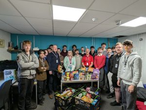A photo of the first year T Level Engineering students wearing fake moustaches, standing next to the food delivery.