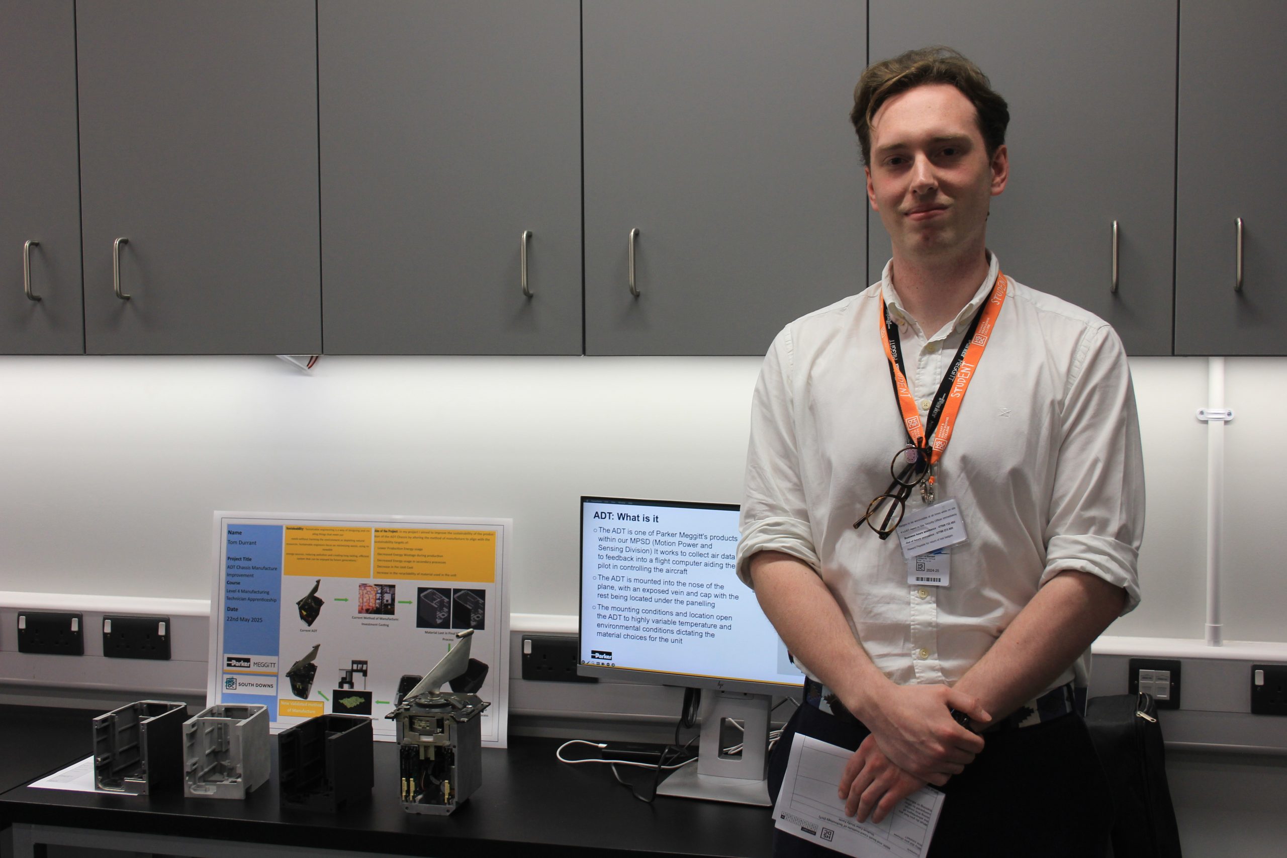 A student stands next to his engineering project.