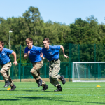 PDS students running across a field.