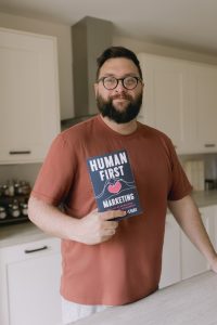 Phil holding a copy of Human First Marketing. 