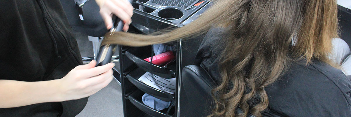 A student curling a client's hair