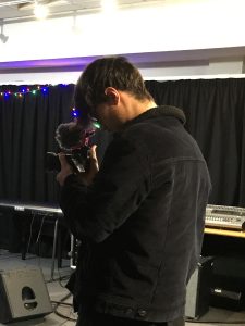 Fin operating a camera on set of the video.