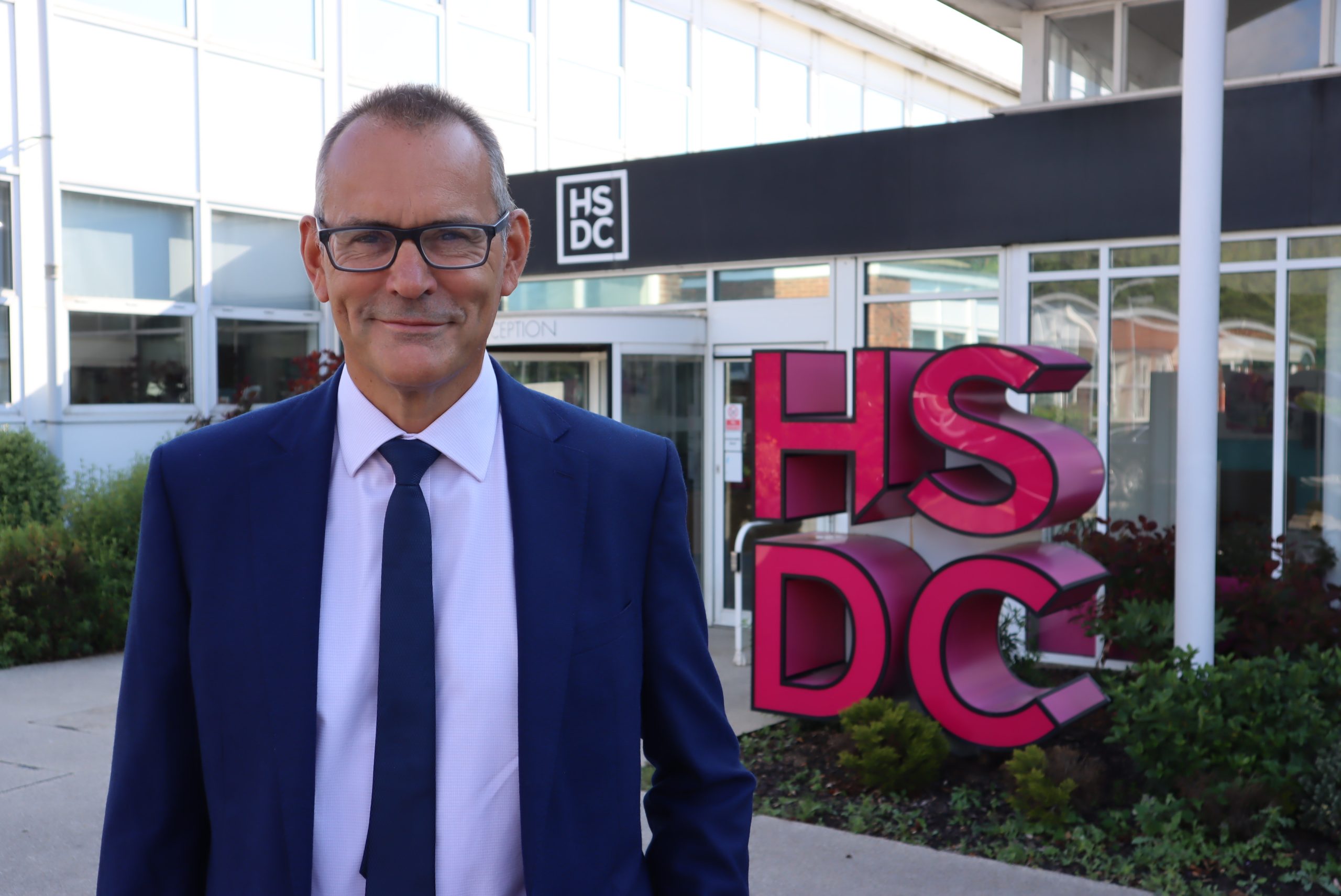 Mike Gaston standing in front of a HSDC sign at Havant Campus.