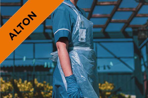 a nurse in scrubs wearing an additional protective apron