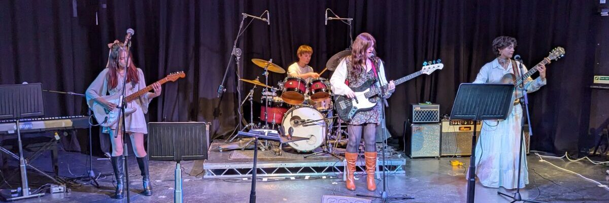 A band comprised of students on stage, performing.