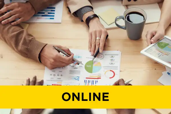 Multiple pairs of hands working on a business plan in the centre of a table.