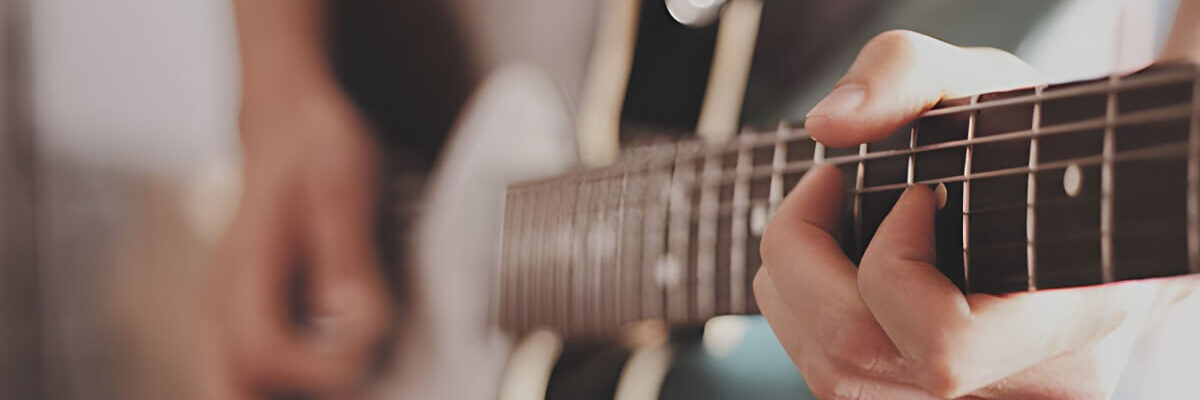 Close up of hands playing guitar.