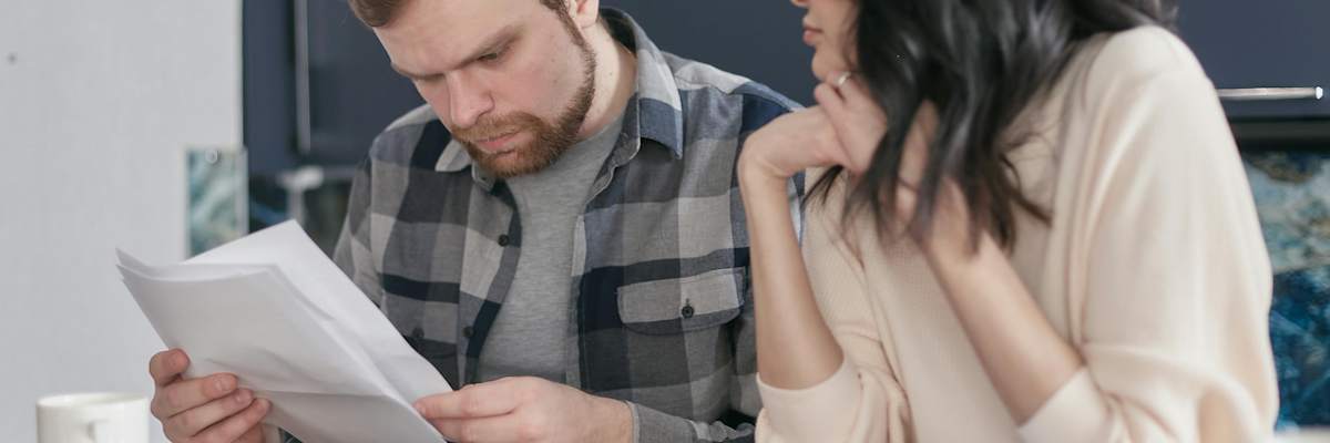 A man and a woman look over a piece of paper.