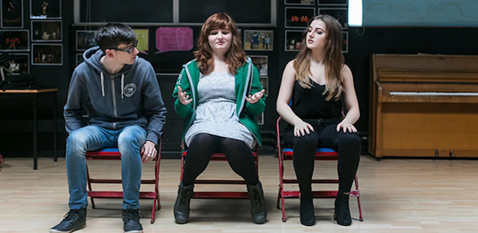 Three students performing in theatre studies.