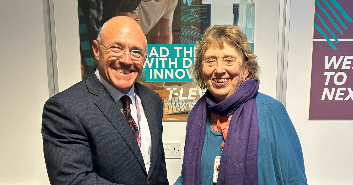 Kurt Hintz and Penny Wycherley shake hands while wearing their new HSDC lanyards.