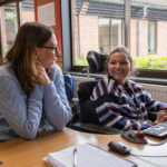 Evie sat at a desk laughing