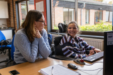 Evie sat at a desk laughing