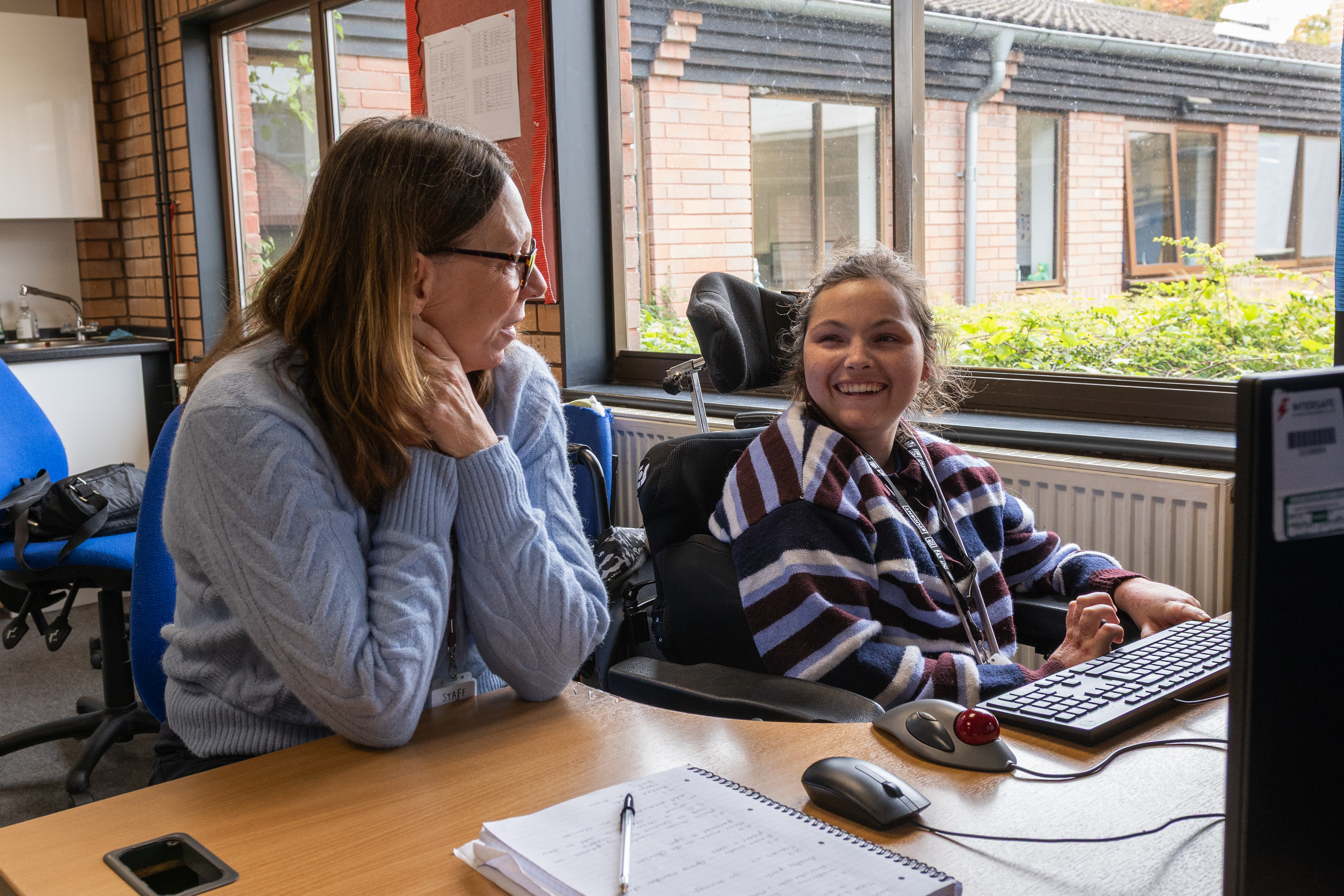 Evie sat at a desk laughing