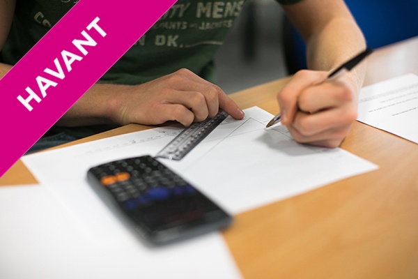 a student using a ruler, pencil and paper with a calculator